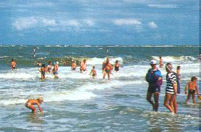 Menschen schwimmen und spielen am Nordseestrand