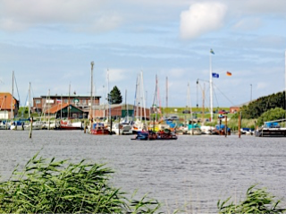 Der Yachthafen in Harlesiel mit Wasser und Schiffen im Hintergrund